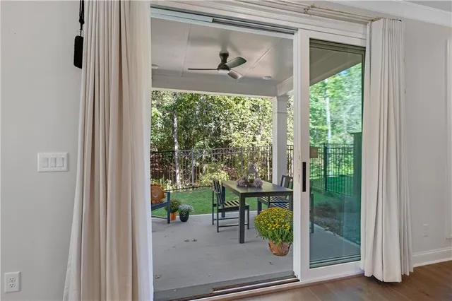 a view of a porch with a floor to ceiling window and garden