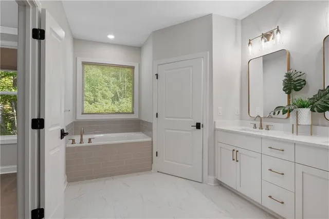 a bathroom with a tub a sink and mirror