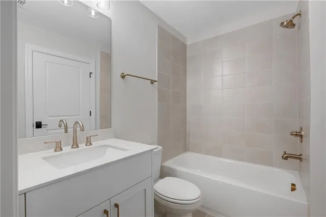 a bathroom with a bathtub shower sink vanity mirror and toilet