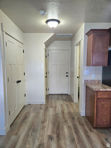601 West 150 North, Unit 25 Springville, UT 84663 - Photo 10 of 29 Entryway featuring wood-finish flooring, white paneled doors with black hardware, and a built-in cabinet with a stone-finish countertop