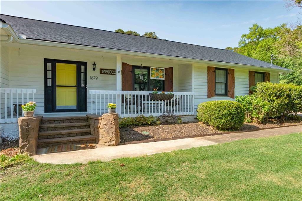 a view of a house with a small yard and flower garden