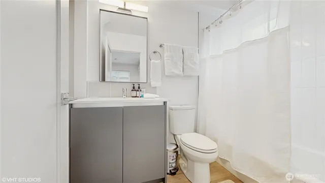 a bathroom with a sink a toilet and a mirror