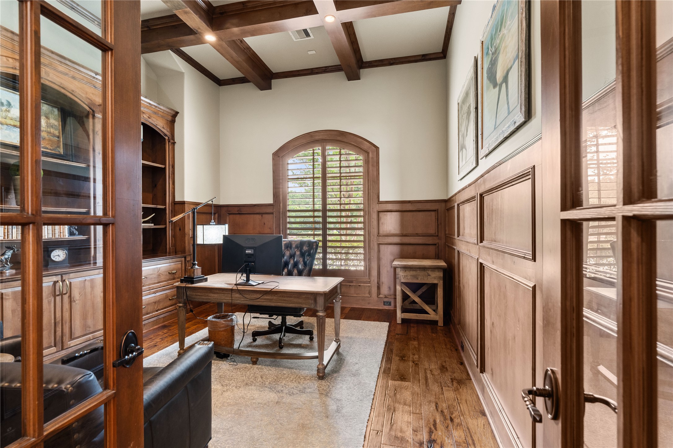12349 Longmire Trace Conroe, TX 77304 - Photo 11 of 48 Private study with rich wood paneling, coffered ceiling, built-in cabinetry, and arched shuttered windows.