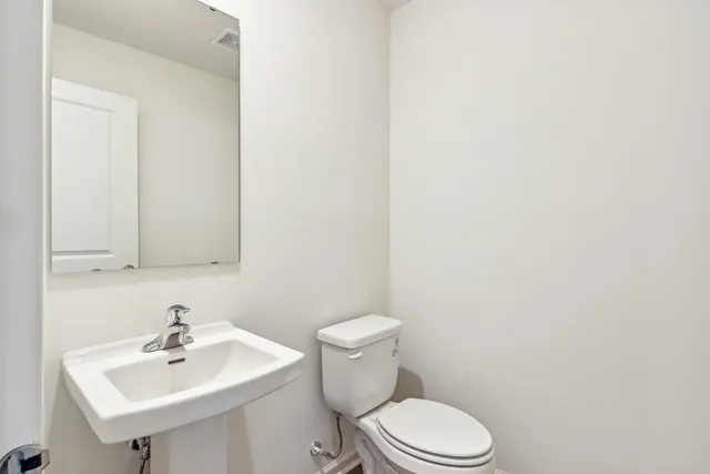 a bathroom with a sink a mirror and a toilet