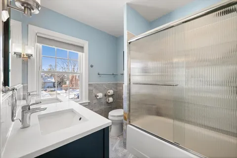 a bathroom with a bathtub shower sink vanity and toilet