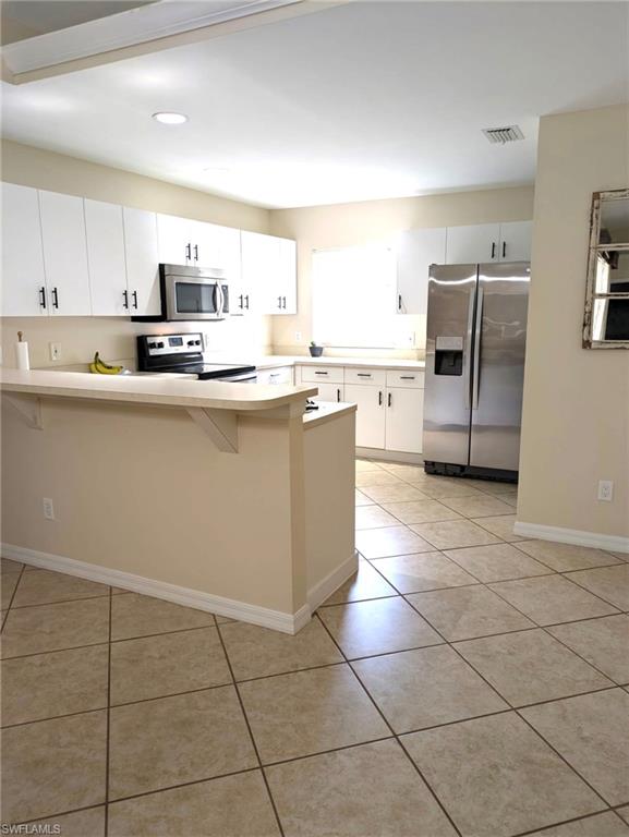 2910 2nd Street Northeast Naples, FL 34120 - Photo 5 of 9 a kitchen with stainless steel appliances a sink a stove a microwave a counter top space and cabinets