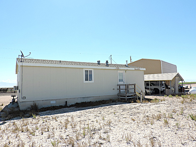 915 North 5000 W Road Hinckley, UT 84635 - Photo 27 of 27 Single-story structure featuring light-colored siding and a dark shingle roof