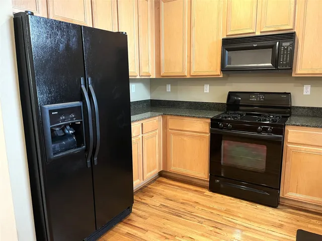 a kitchen with stainless steel appliances granite countertop a refrigerator and a stove top oven