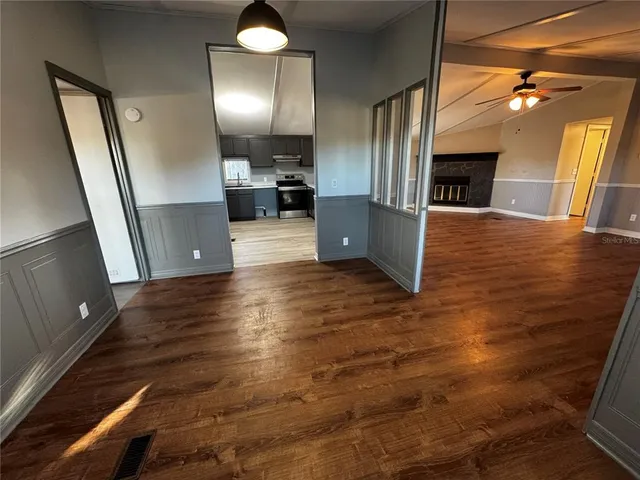 an empty room with wooden floor and staircase
