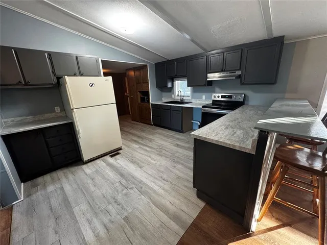a kitchen with a refrigerator and a stove top oven