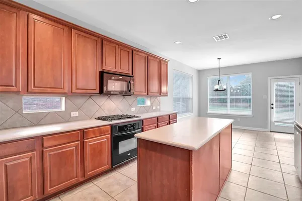 a kitchen with granite countertop stainless steel appliances a stove sink and cabinets