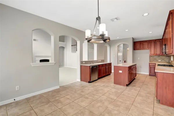 a large kitchen with a large counter top stainless steel appliances and cabinets