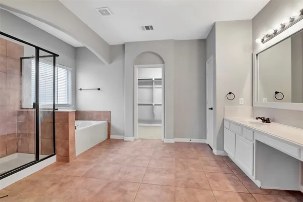 a large bathroom with a tub shower and sink