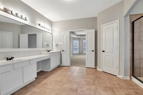 a large bathroom with a large mirror vanity and a sink