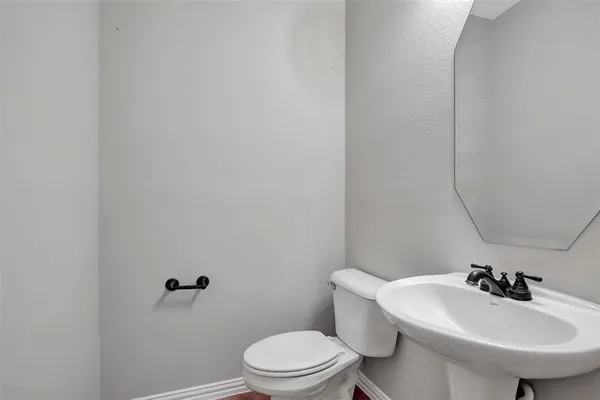 a bathroom with a sink toilet and mirror