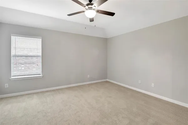 an empty room with a window and a fan