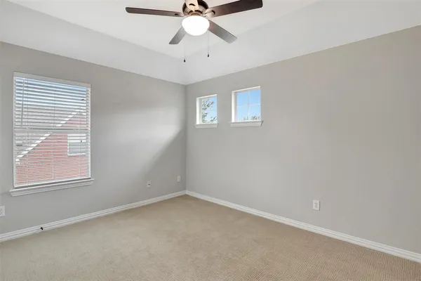 an empty room with a window and a fan
