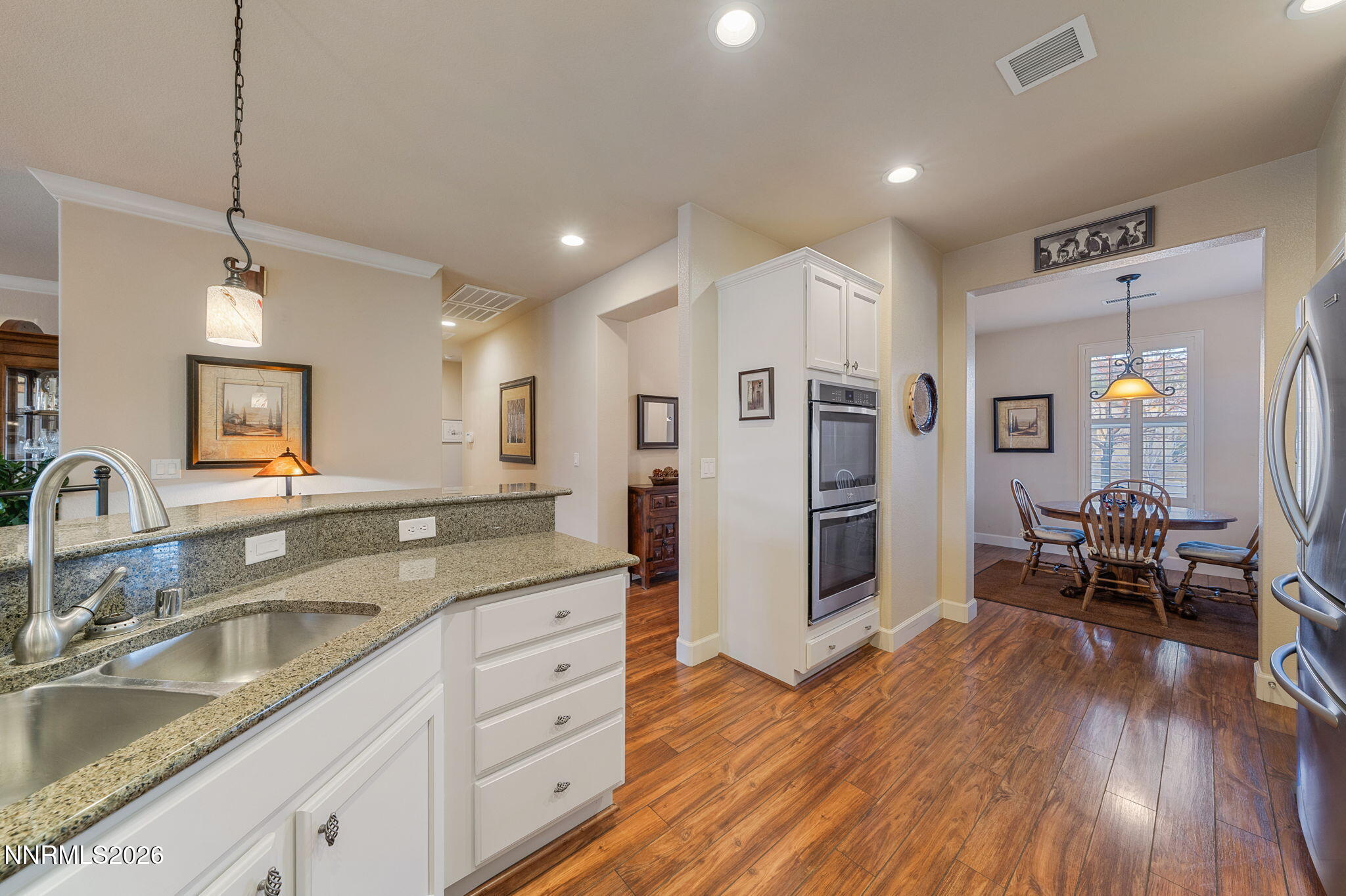 9370 Rockhurst Court Reno, NV 89523 - Photo 17 of 40 a kitchen with stainless steel appliances granite countertop a refrigerator a sink dishwasher a oven and white cabinets with wooden floor