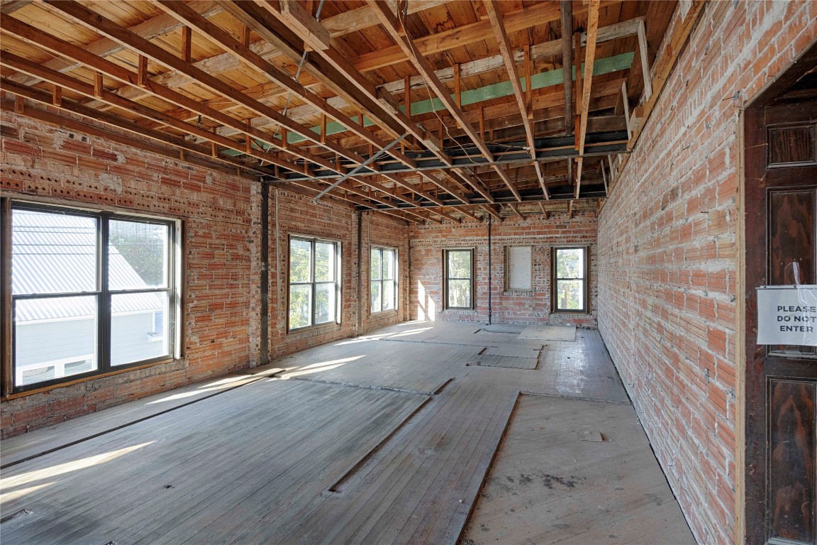 607 Lyons Avenue Schulenburg, TX 78956 - Photo 19 of 27 a view of an empty room with wooden floor and a window