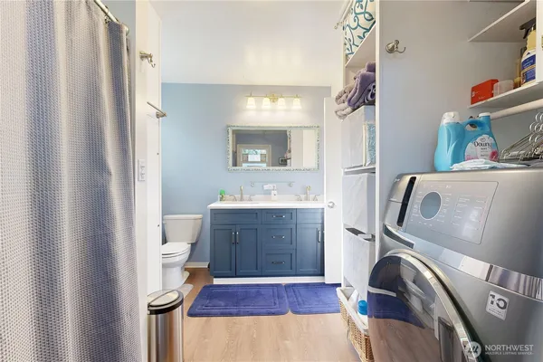 a bathroom with a toilet a sink a vanity a mirror and a window