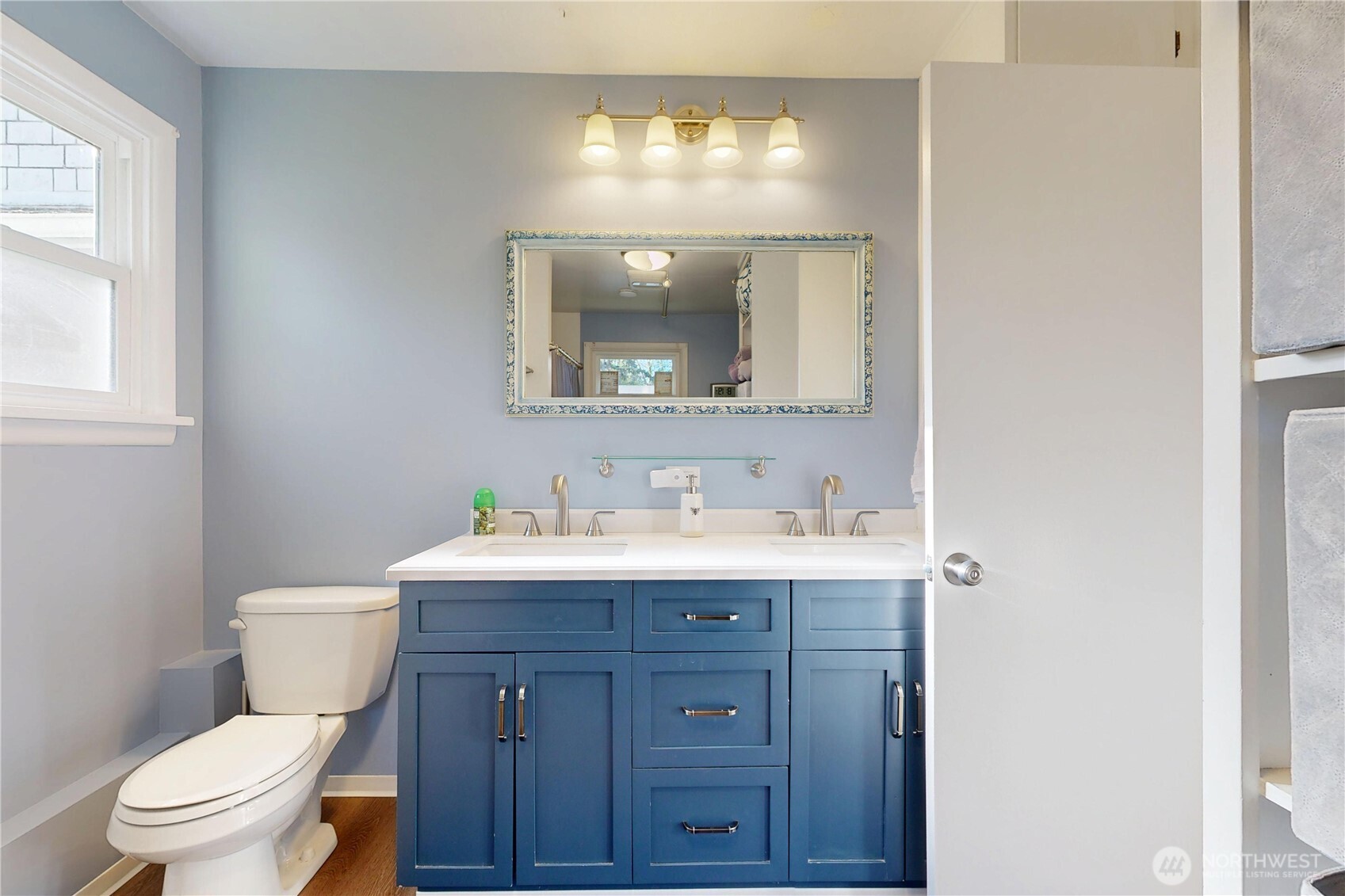 821 East Chestnut Street Walla Walla, WA 99362 - Photo 15 of 39 a bathroom with a toilet a sink a vanity a mirror and a window