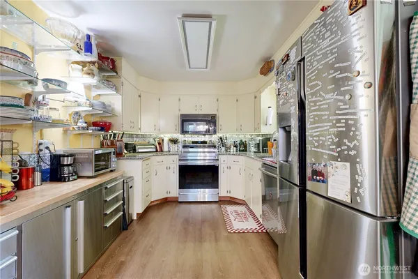 a kitchen with stainless steel appliances granite countertop a refrigerator and a stove