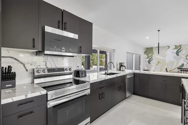 a kitchen with stainless steel appliances kitchen island granite countertop a sink and cabinets