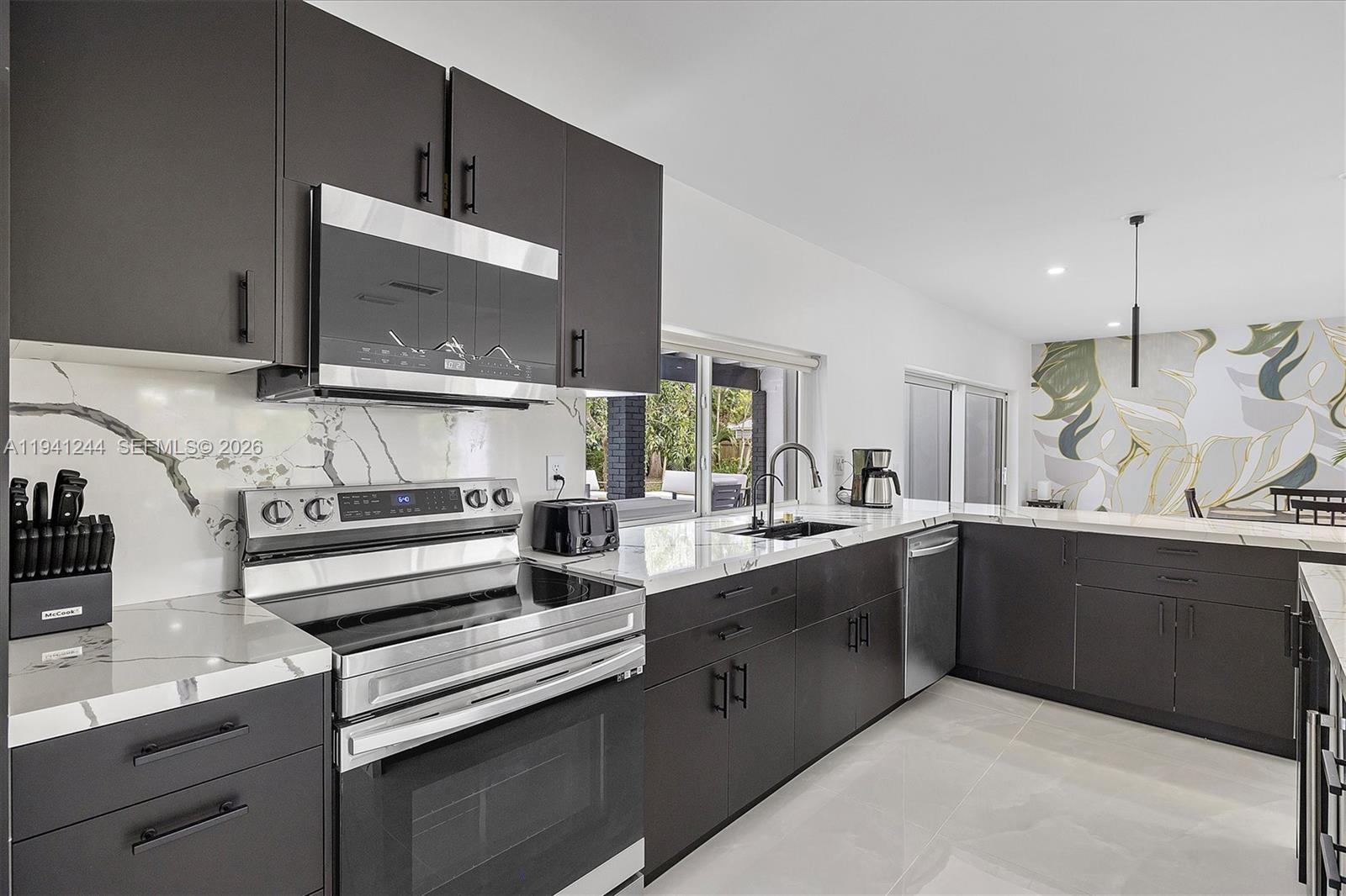 10361 Southwest 119th Street Miami, FL 33176 - Photo 11 of 38 a kitchen with stainless steel appliances kitchen island granite countertop a sink and cabinets
