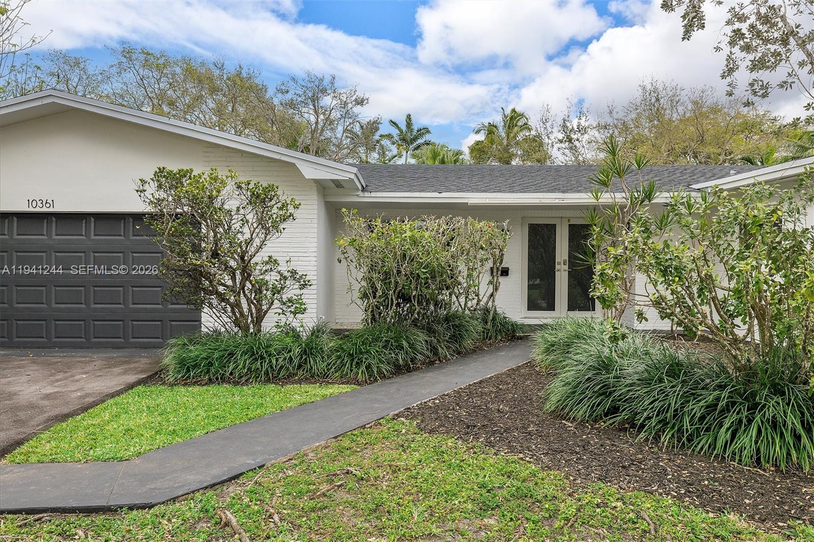 10361 Southwest 119th Street Miami, FL 33176 - Photo 2 of 38 a view of a yard in front of a house with a large tree