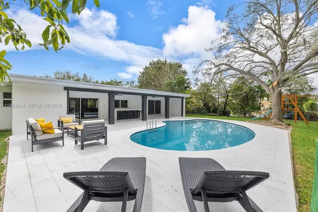 a roof deck with table and chairs and potted plants