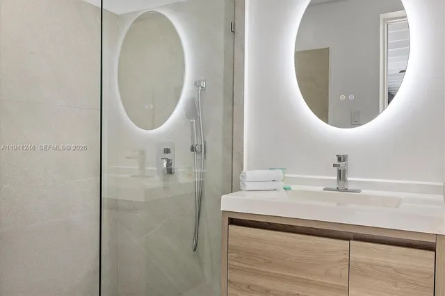 a bathroom with a sink a mirror and a shower