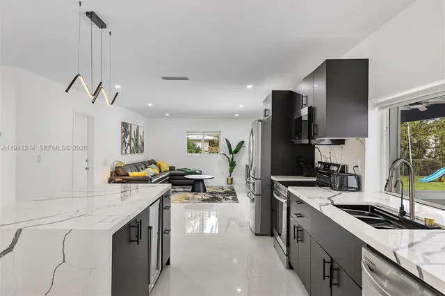 a kitchen with stainless steel appliances granite countertop a sink stove and refrigerator