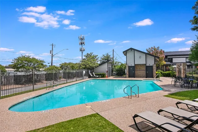 a view of a swimming pool with a patio and a yard