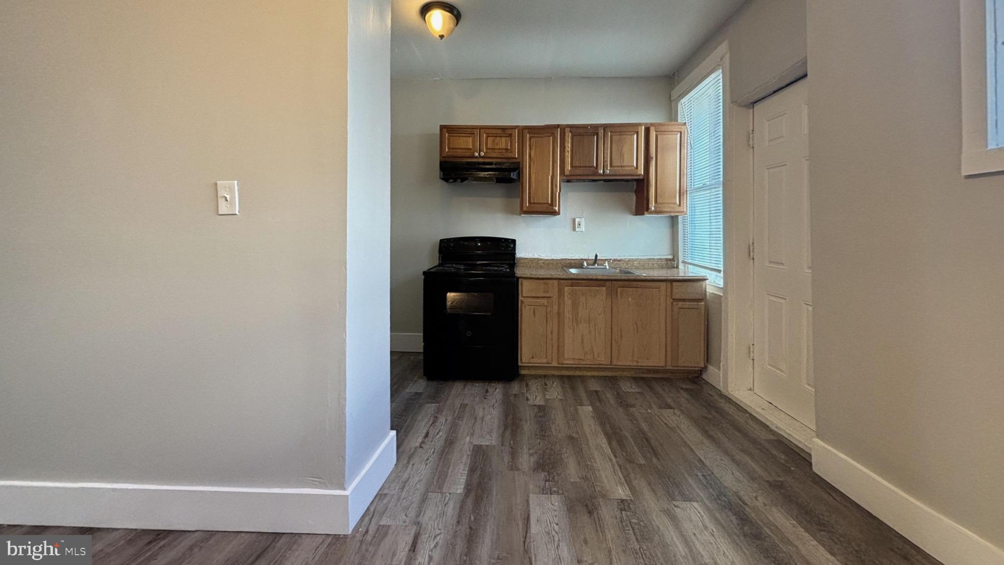 5581 Blakemore Street Philadelphia, PA 19138 - Photo 3 of 14 a kitchen with wooden cabinets and a stove