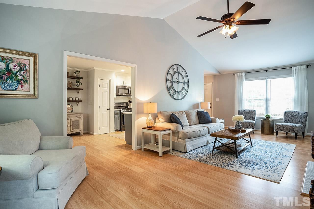 8105 Brumbley Place Raleigh, NC 27612 - Photo 6 of 23 a living room with furniture a clock and a window