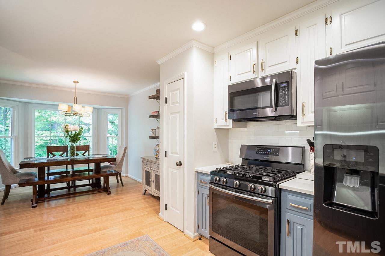 8105 Brumbley Place Raleigh, NC 27612 - Photo 7 of 23 a kitchen with stainless steel appliances a stove a sink and a refrigerator