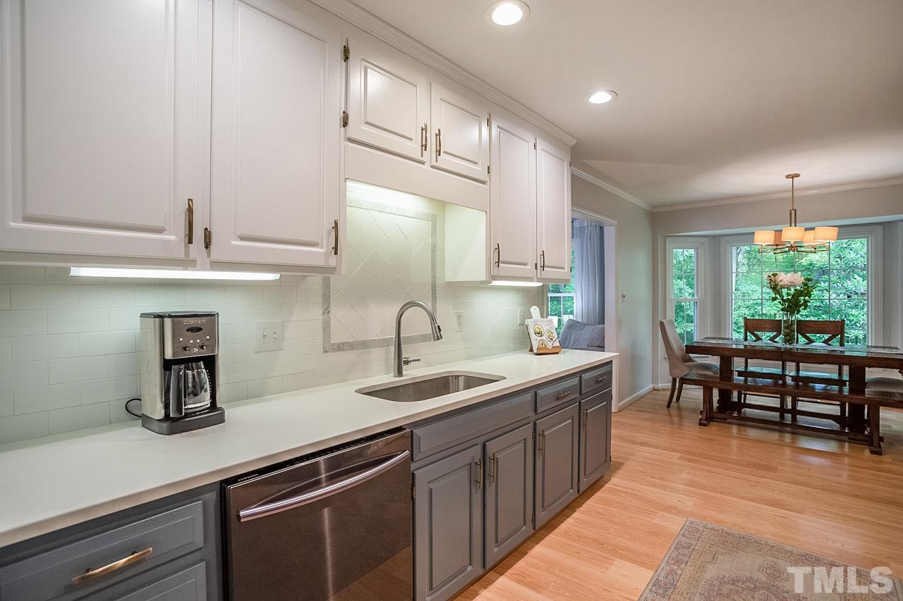 8105 Brumbley Place Raleigh, NC 27612 - Photo 8 of 23 a kitchen with stainless steel appliances granite countertop a sink and a refrigerator