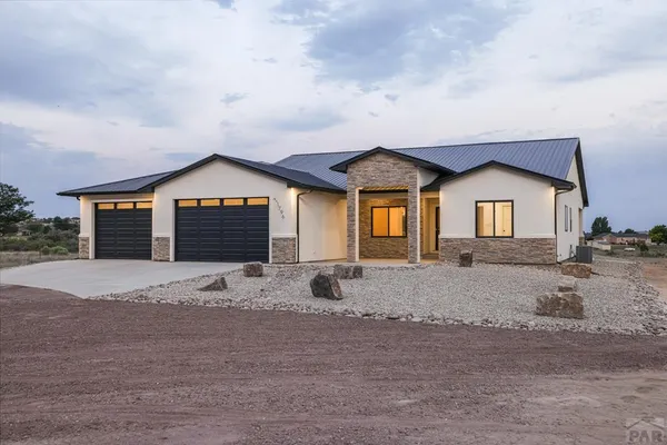 a large kitchen with stainless steel appliances a large counter top a sink a stove and a refrigerator