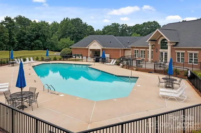 a view of a house with pool and chairs