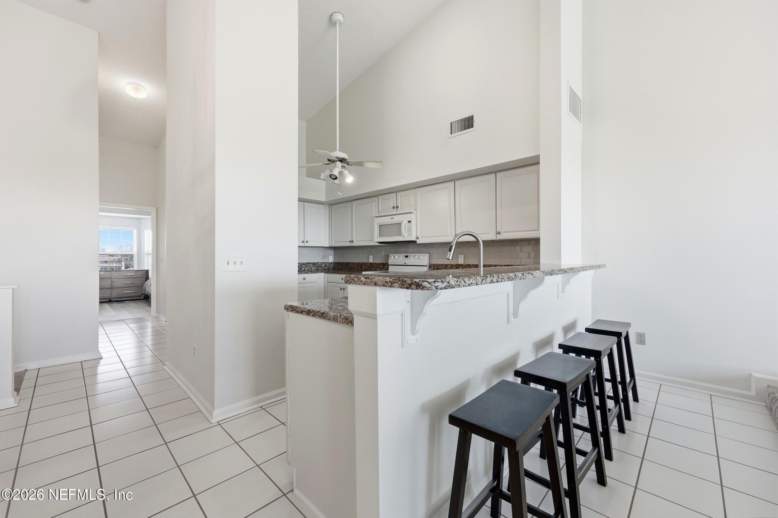 3331 Lighthouse Point Lane Jacksonville, FL 32250 - Photo 19 of 63 a kitchen with kitchen island cabinets and chairs in it