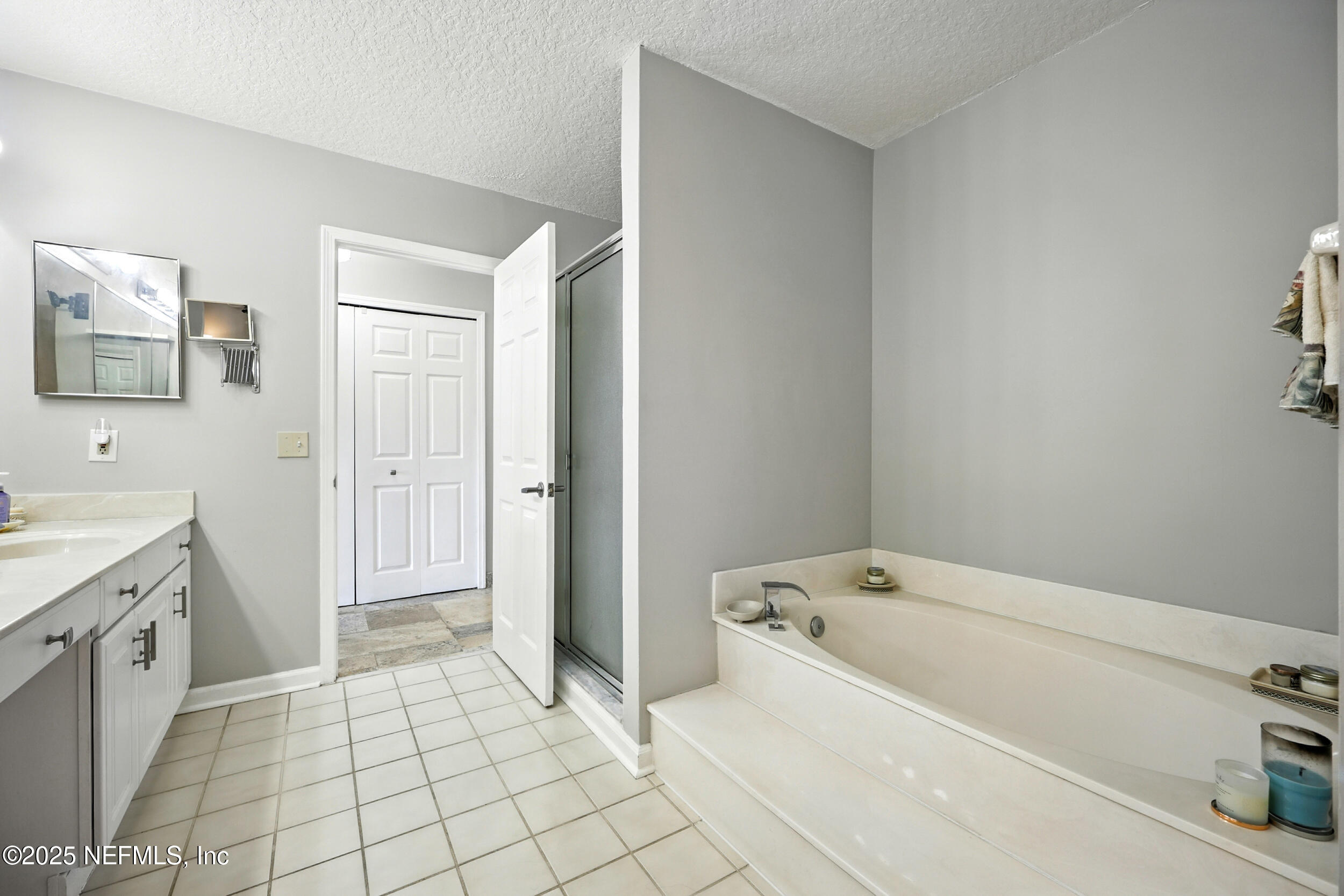 3331 Lighthouse Point Lane Jacksonville, FL 32250 - Photo 28 of 63 a spacious bathroom with a tub sink and mirror