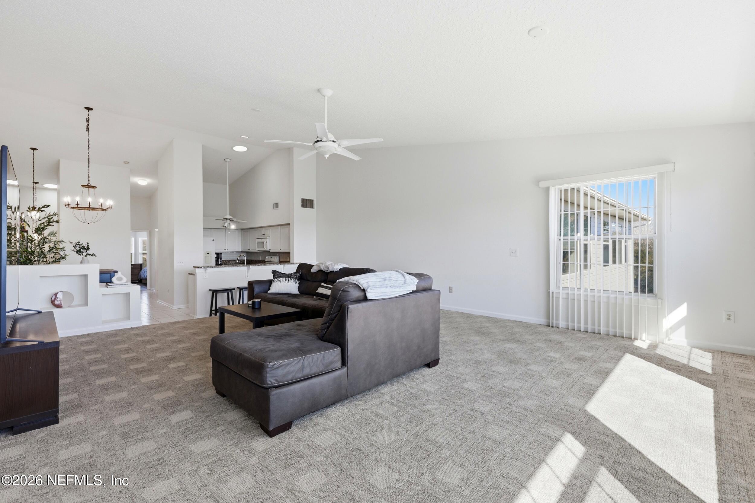 3331 Lighthouse Point Lane Jacksonville, FL 32250 - Photo 10 of 63 a living room with furniture and a chandelier