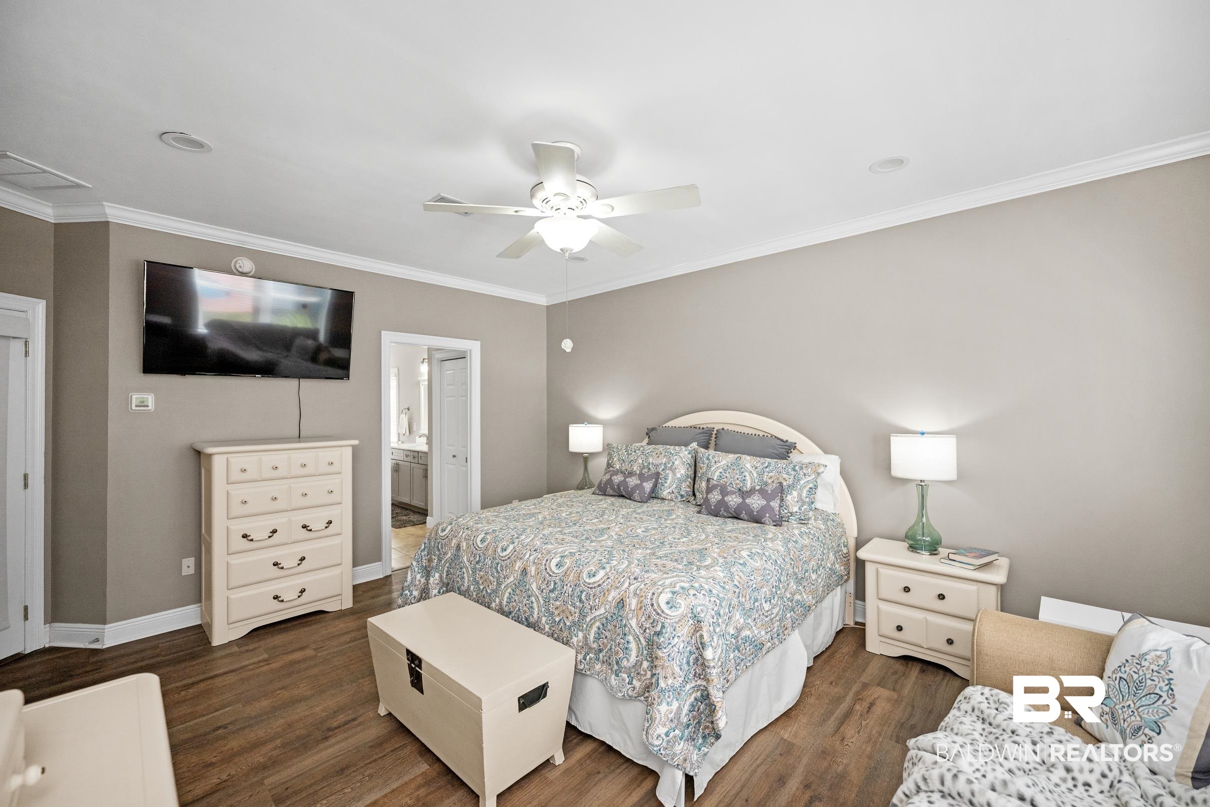 5217 Greentree Road Orange Beach, AL 36561 - Photo 38 of 58 Bedroom featuring dark wood-style floors, ensuite bath, crown molding, and a ceiling fan
