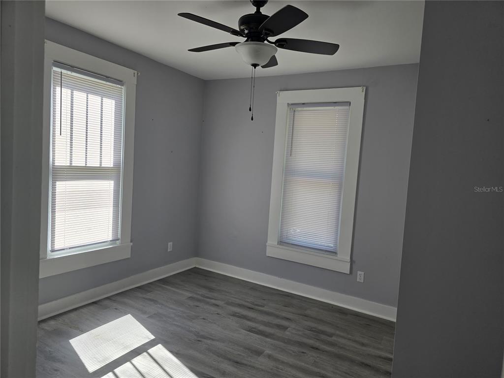 326 Southeast 2nd Street Williston, FL 32696 - Photo 17 of 30 an empty room with wooden floor fan and windows