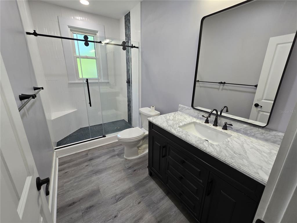 326 Southeast 2nd Street Williston, FL 32696 - Photo 21 of 30 a bathroom with a granite countertop sink toilet and shower