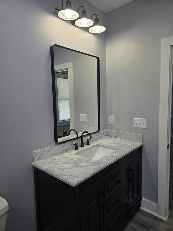 326 Southeast 2nd Street Williston, FL 32696 - Photo 23 of 30 a bathroom with a granite countertop sink and a mirror