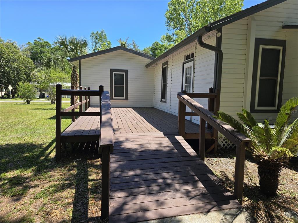 326 Southeast 2nd Street Williston, FL 32696 - Photo 30 of 30 a view of a patio with table and chairs with wooden floor and fence
