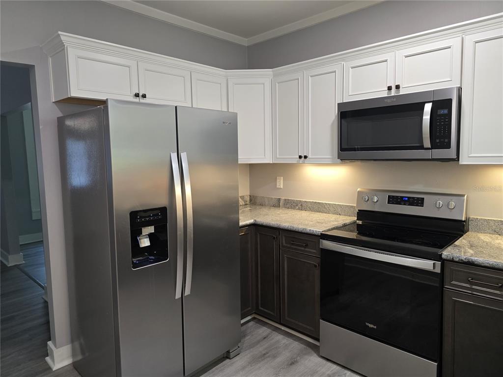 326 Southeast 2nd Street Williston, FL 32696 - Photo 4 of 30 a kitchen with cabinets stainless steel appliances and a counter space