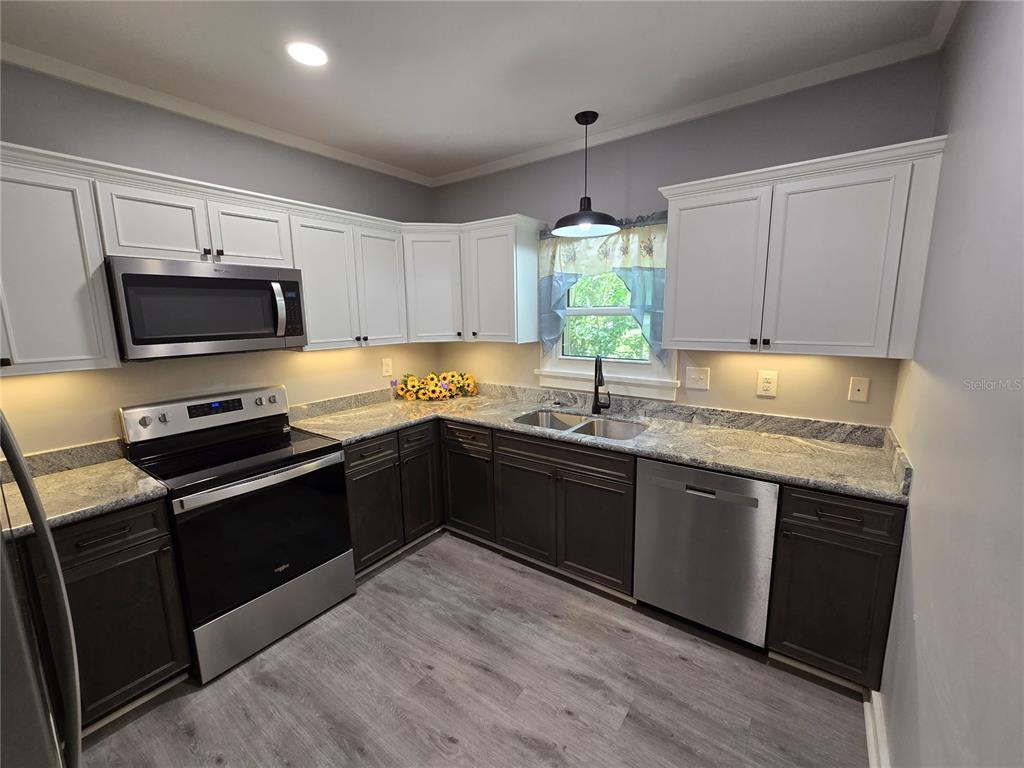 326 Southeast 2nd Street Williston, FL 32696 - Photo 5 of 30 a kitchen with granite countertop a stove sink and cabinets