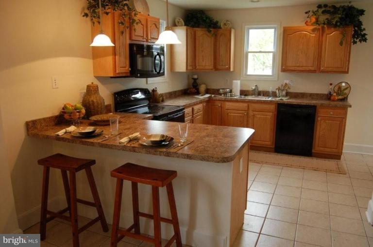 28 Crafton Road Essex, MD 21221 - Photo 6 of 13 a kitchen with a sink a stove and chairs
